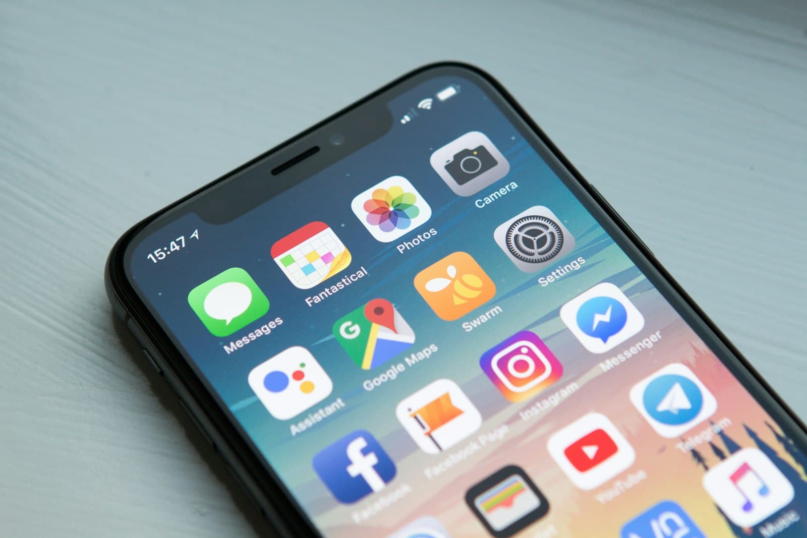Close-up of an iPhone home screen showing maps, messages, and other apps