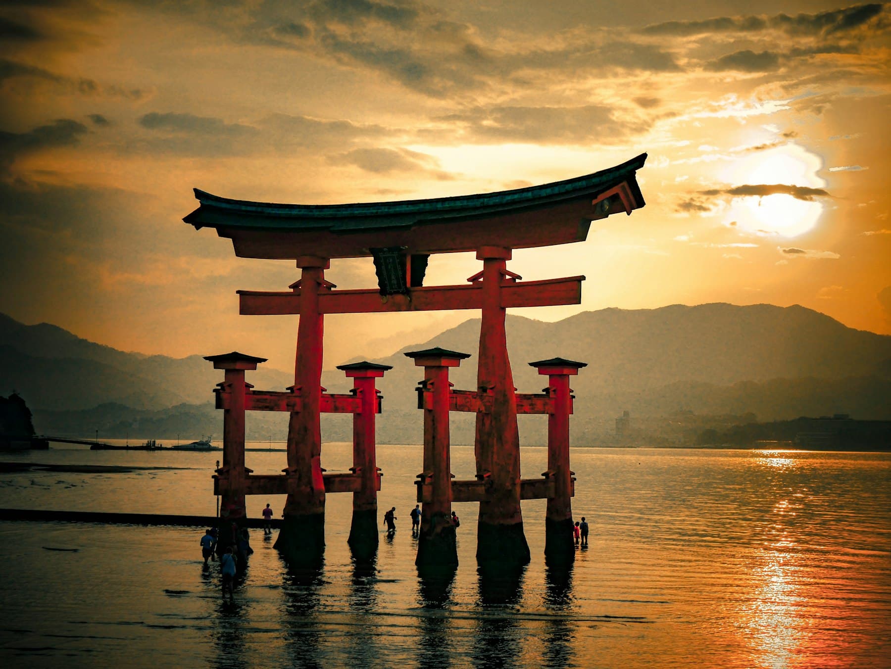 The vermilion torii of Itsukushima Shrine standing in the water at Miyajima, near Hiroshima, at sunset