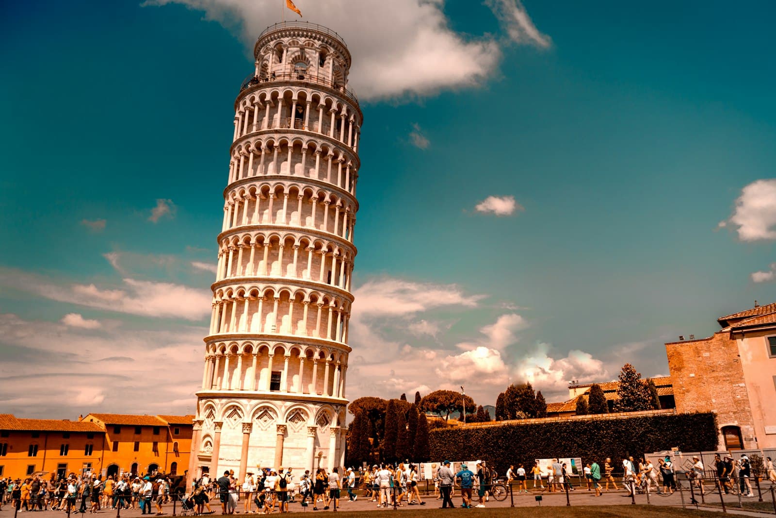 The Leaning Tower of Pisa with visitors on the lawn in front